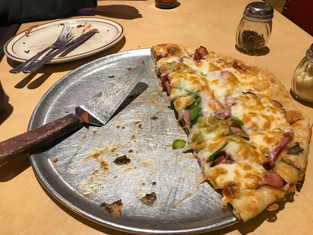 Hald a pie of Regina style pizza on a table