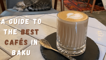 Baku Cafes blog post cover image - latte art with a cat sleeping on a chair in the background