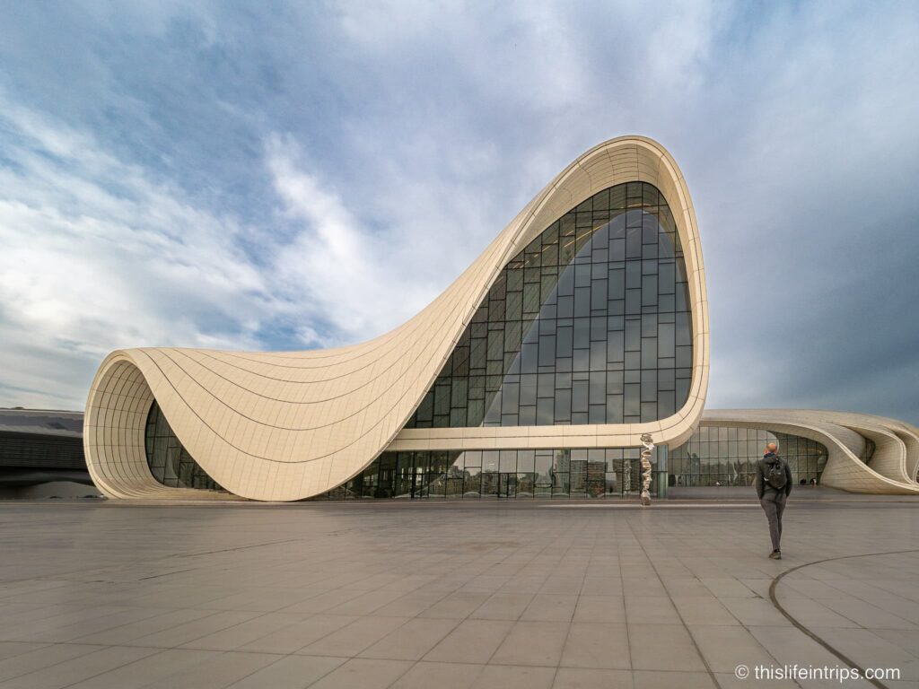 Visit the Heydar Aliyev Center exterior with man walking towards it.