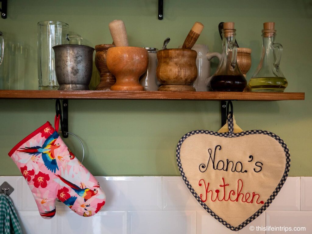Nana's kitchen rack with oils, spices, and a oven mit hanging