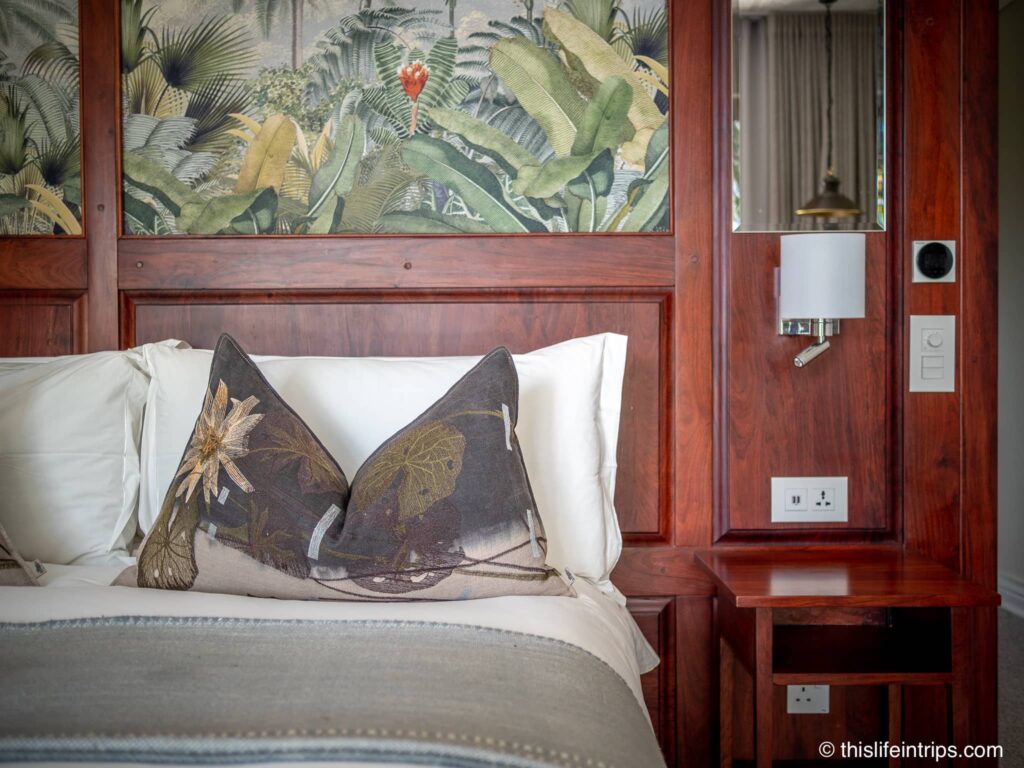 Palm River Hotel bed with wood trim and palm tree images on headboard