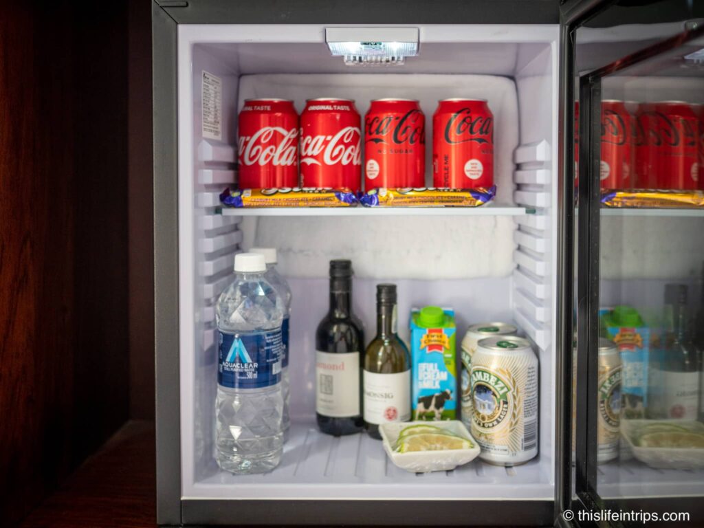 Mini fridge with Coca cola, water, wine, and beer