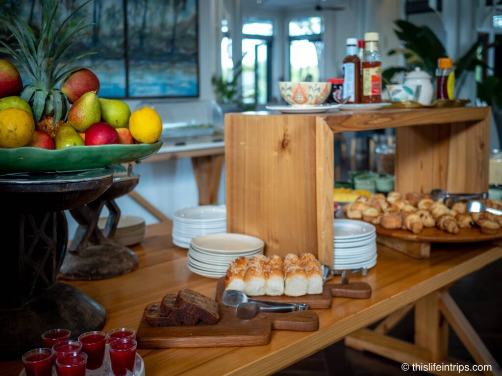 Palm River Lodge Victoria Falls breakfast buffet with bowl of fruit in foreground and a selection of pastries behind it.