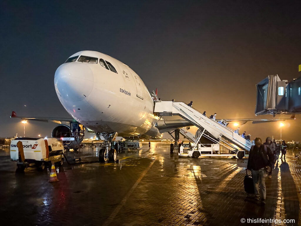 passengers deplaning Turkish Airlines A330-200 aircraft at night at Nairobi airport
