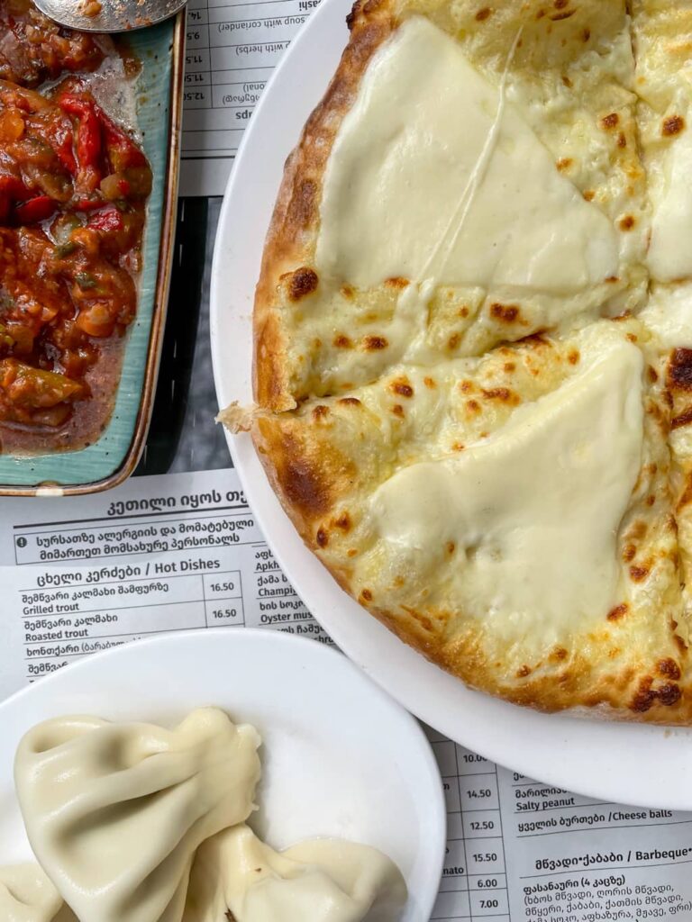 top down image of Khachapuri with a plate of khinkali below it