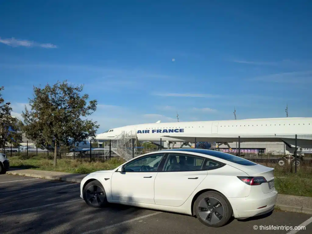 Tesla Model 3 parked along side a Concord the Airbus Museum in Toulouse France