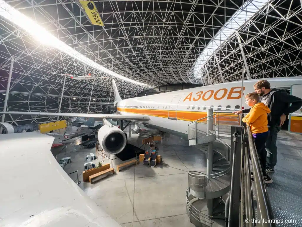 Lots to learn at the Toulouse Airbus museum - man pointing out something to his son at the museum