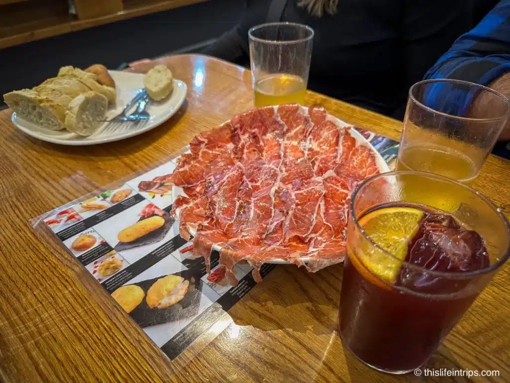 Large plate of Iberia ham at a San Sebastian tapa bar with a glass of sangria in front
