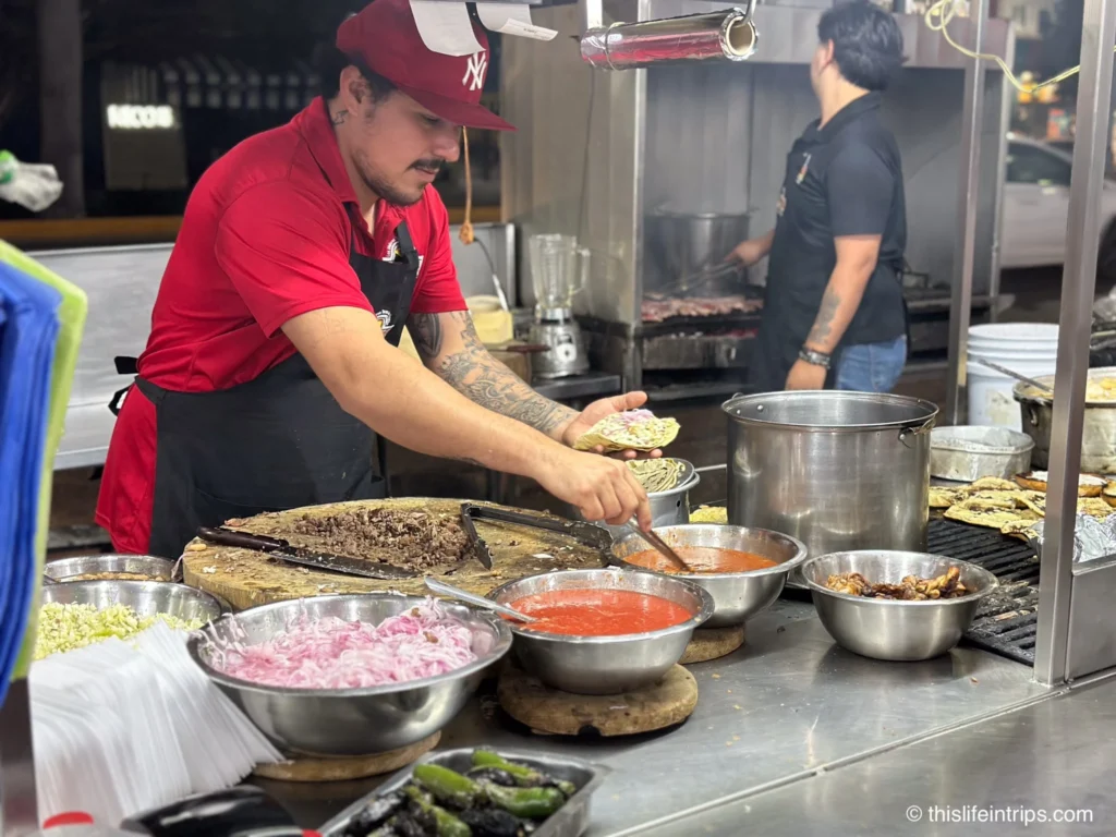 Man serving street tacos while on a Mazatlan food tour
