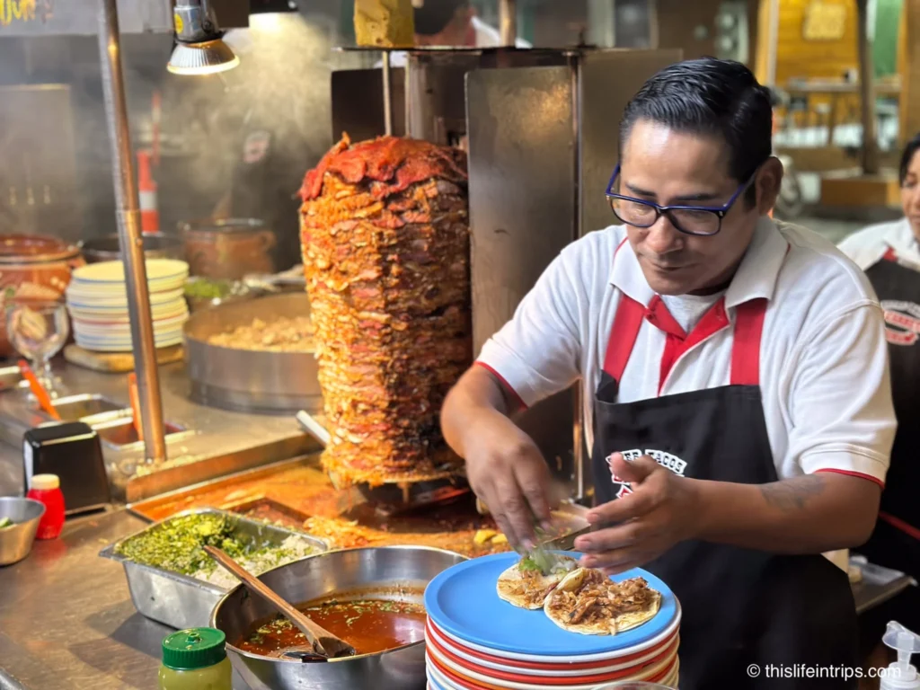 Man serving Al Pstor street tacos on a Mazatlan food tour