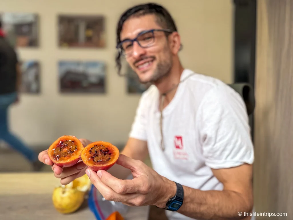 Man holding up cut fruit on Medellin food tour