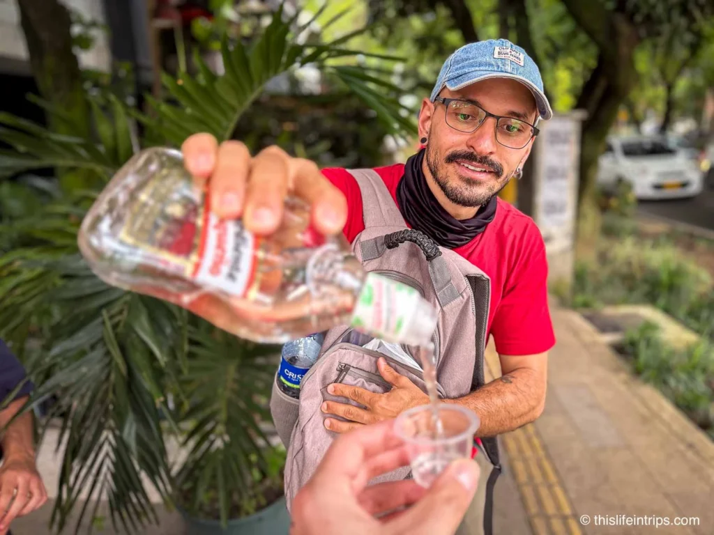 guide pouring a drink on the best Medellin food tour